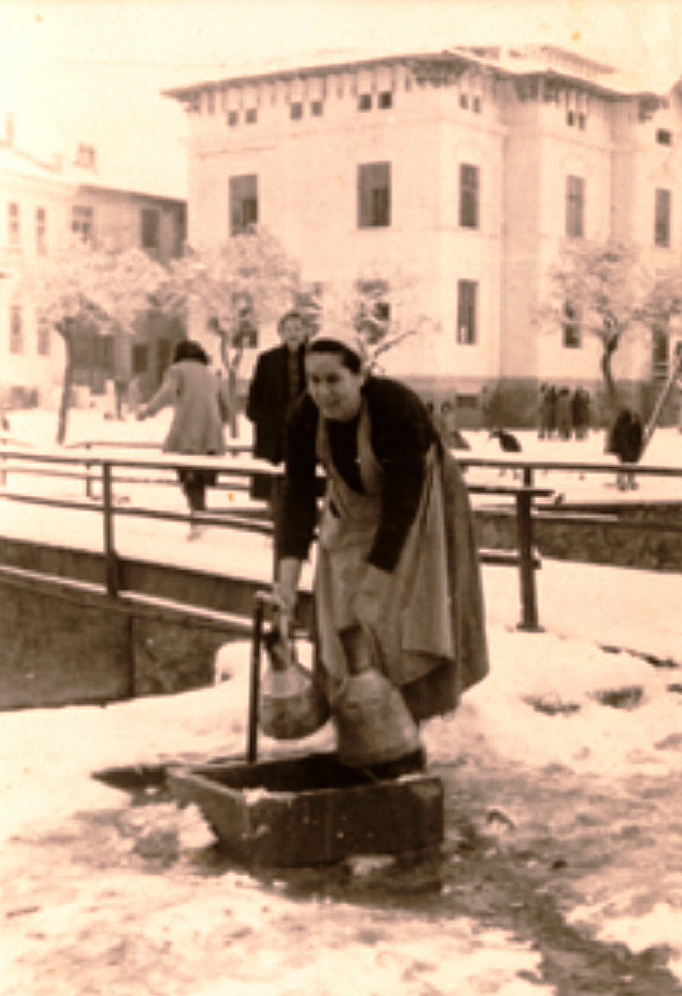 Αρχές δεκαετίας του 1950. Η κυρία Πασχαλιά στη βρύση για νερό. (Αρχείο Δημήτρη Μεκάση)